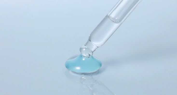 This may contain: a blue liquid in a test tube on a white surface